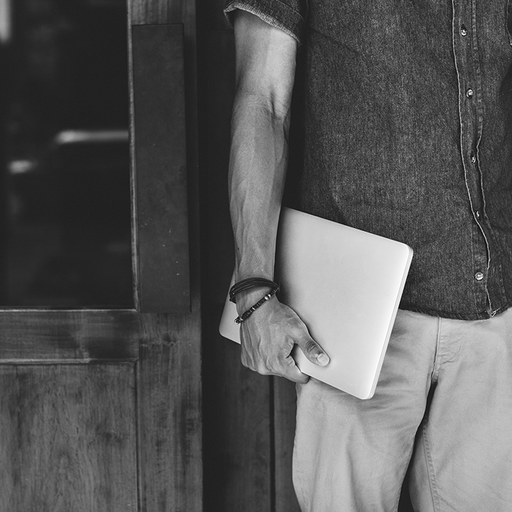 photo de mode homme tenant un pc noir et blanc